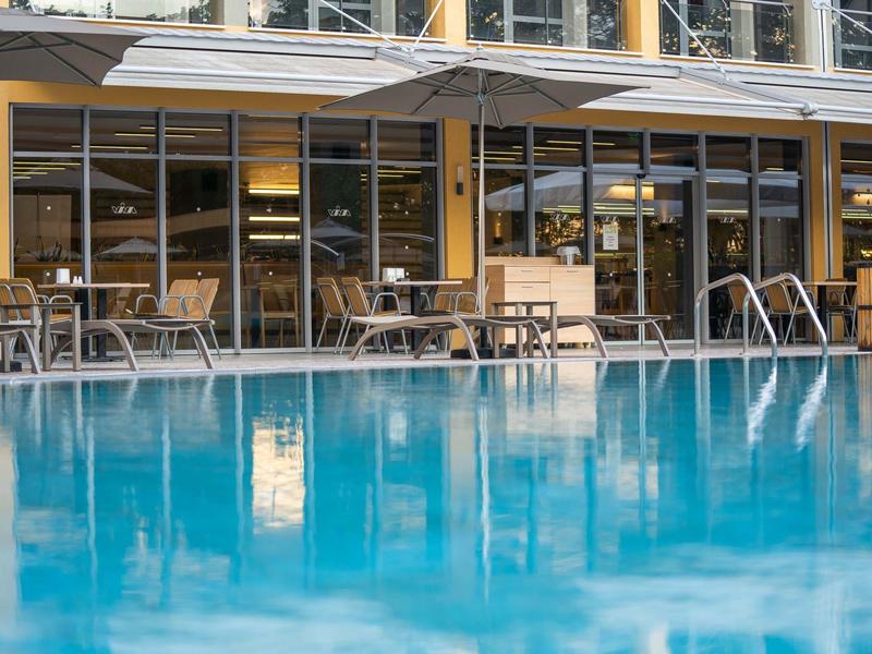 Zwembad voor een hotelterras met stoelen en tafels