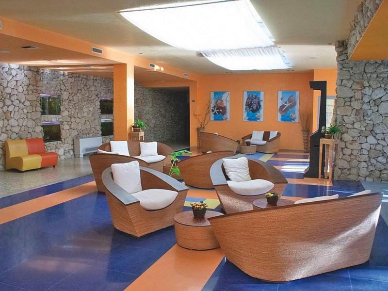 Moderní hotelový salonek s dřevěným a kamenným dekorací a pohodlným posezením.