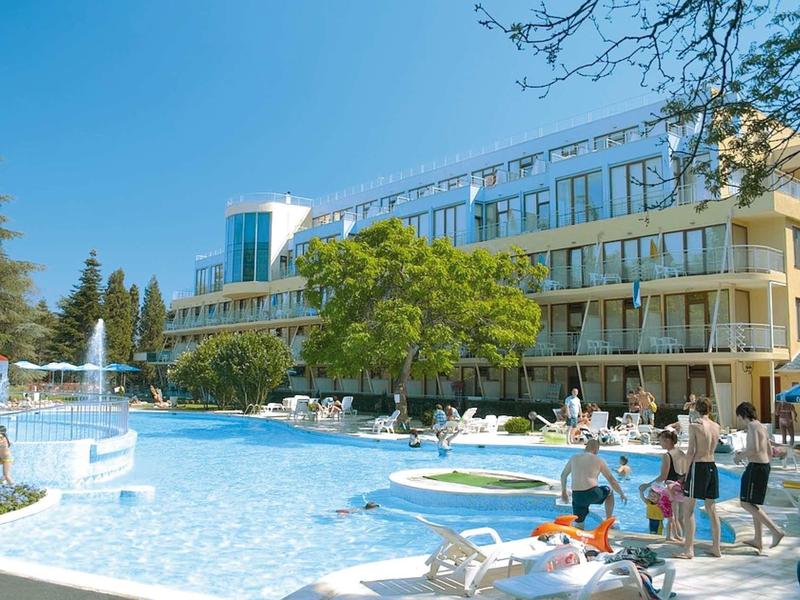 Hotel s velkým venkovním bazénem obklopeným lehátky a hosty.