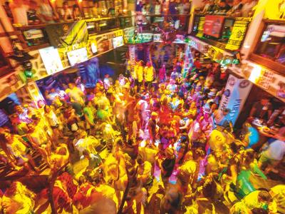 Belebter Innenraum einer Discothek mit vielen tanzenden Menschen und bunten Lichtern