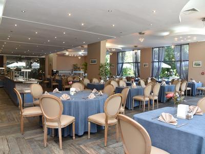 Sala de comedor elegante con manteles azules y sillas cómodas en ambiente luminoso.