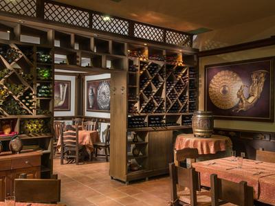 Accogliente cantina con mobili in legno, scaffali per vino e decorazioni rustiche.