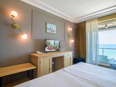 Modern eingerichtetes Hotelzimmer mit Blick auf das Meer und Balkon.