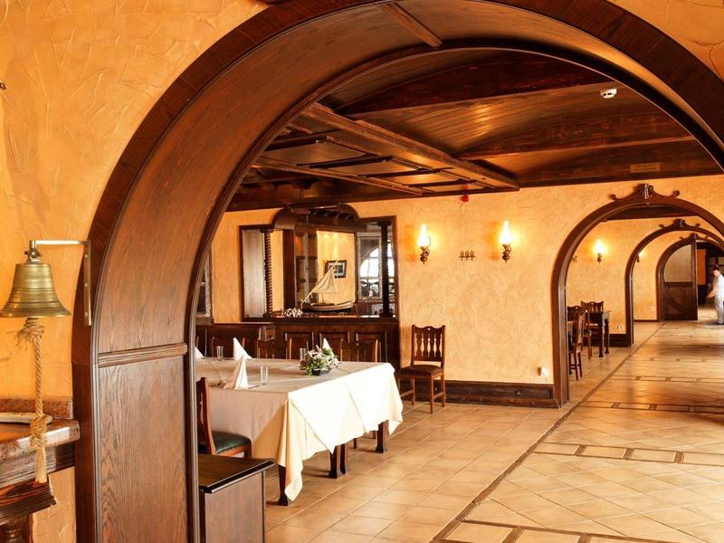 Large arched wooden doorway in an elegantly furnished hotel restaurant.