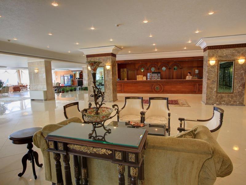 Spacious hotel lobby area with elegant furniture and a reception desk in the background.