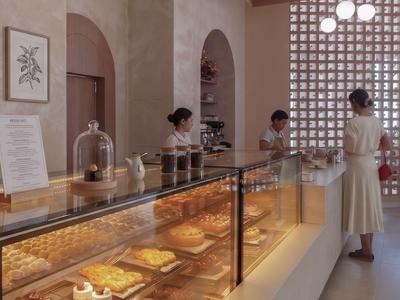 Modern hotel bakery with illuminated counter and customer service.