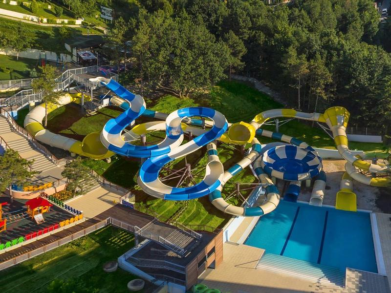 Parc aquatique avec plusieurs toboggans sinueux et une grande piscine