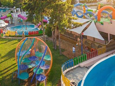 Blick auf einen bunten Wasserpark mit Rutschen und Pflanzen, ideal für Hotelurlaub.