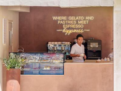Moderne Gelateria mit minimalistischer Theke und Espresso-Automat, ruhiger Ambiente.