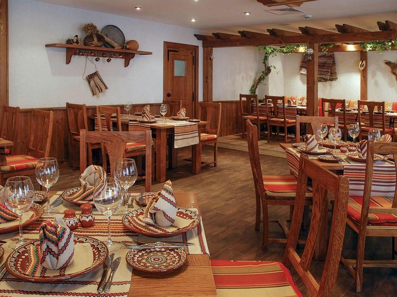 Rustiek restaurant met houten meubels, gedekte tafels en warme sfeer.