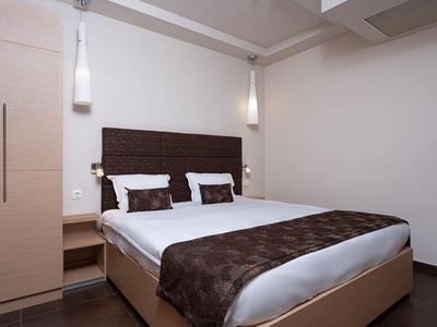 Modern bedroom with double bed, wooden furniture, and minimalist decor.