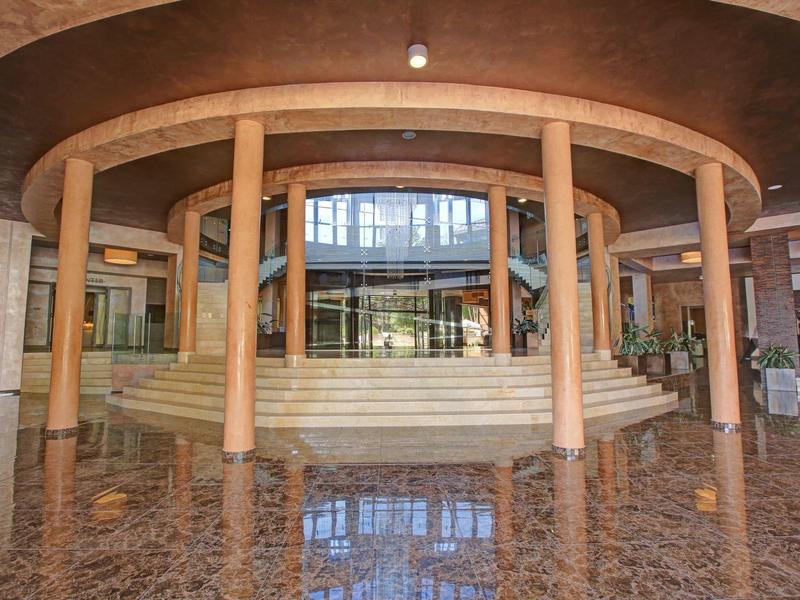 Großer Hotellobby-Eingang mit Marmorboden, Säulen und breiter Treppe.