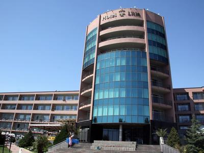 Edificio di un hotel moderno con torre rotonda in vetro e cielo limpido sullo sfondo