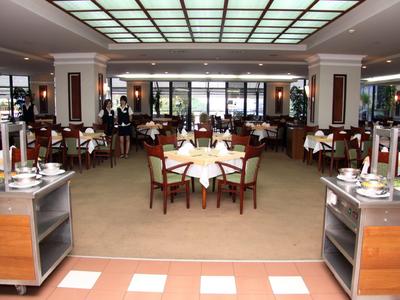 Ampia e elegante sala da pranzo dell'hotel con tavoli apparecchiati e sedie.