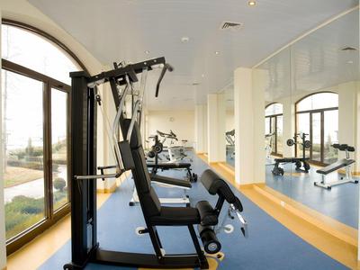 Restaurant en terrasse élégant avec vue sur la mer, table dressée et ciel bleu.
