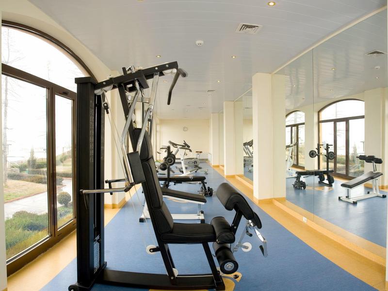 Elegant terrace restaurant with sea view, set table, and blue sky.