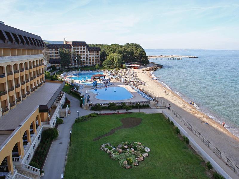 View of a hotel with pool, beach, and sea on a clear day.
