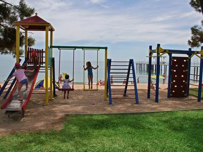 Slaapkamer met groot bed, nachtkastjes en gordijnen bij de ramen.