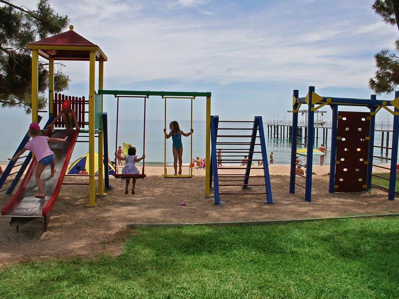 Slaapkamer met groot bed, nachtkastjes en gordijnen bij de ramen.