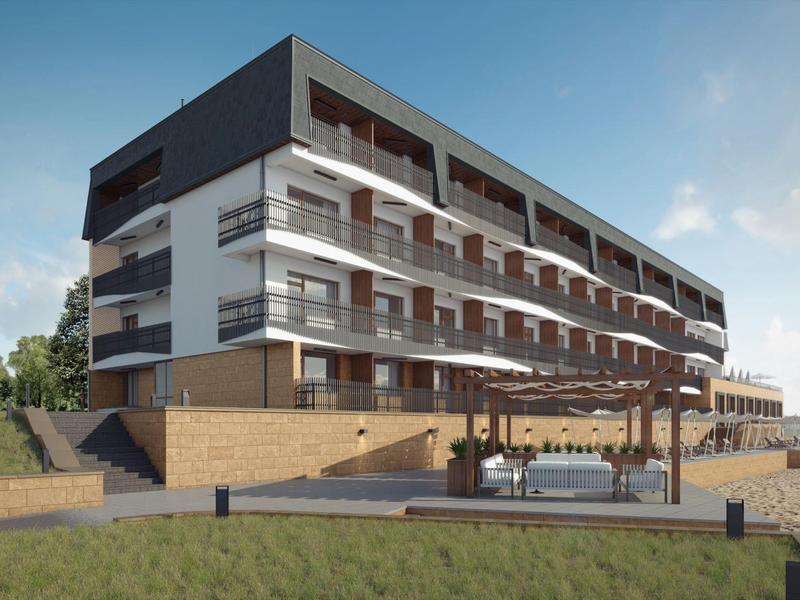 Moderní hotelová budova s několika balkony a venkovní loungovou zónou pod jasnou oblohou.