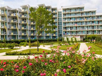 Complexe hôtelier moderne avec chambres avec balcon et jardin bien entretenu avec des roses