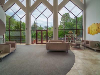 Spacious hotel lobby with tall glass windows and modern seating furniture.