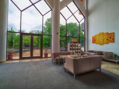 Large hotel lounge area with tall windows and comfortable seating arrangements