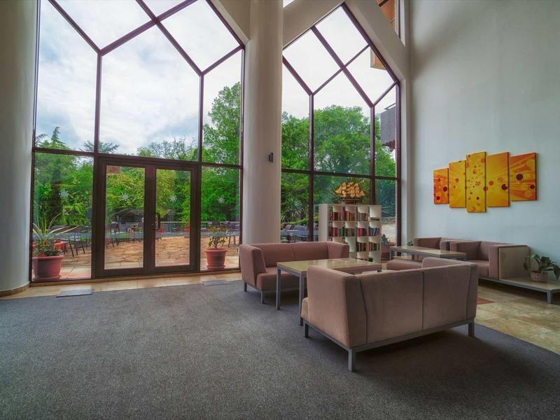 Large hotel lounge area with tall windows and cozy seating arrangements.