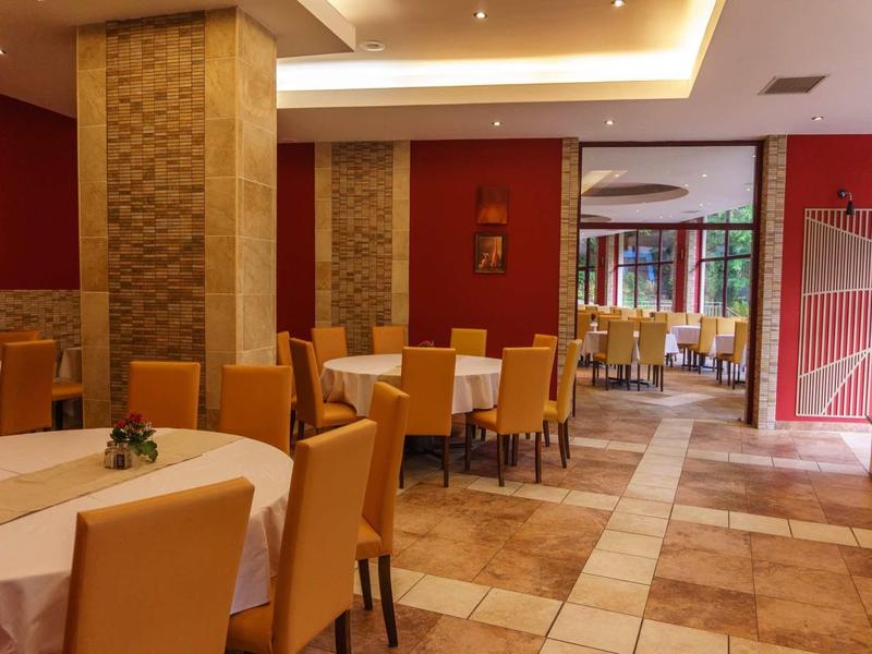 Cozy indoor restaurant area with yellow chairs and round tables.