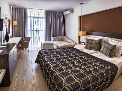 Chambre d'hôtel moderne avec lit double, lit simple, télévision et balcon