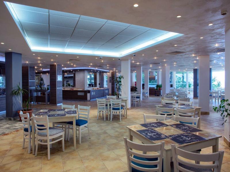 Salle à manger moderne et lumineuse avec tables et chaises dans un hôtel.