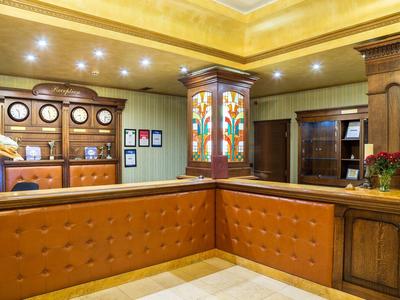 Elegante reception d'hotel con divano in pelle marrone e banco in legno classico.