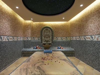 Een luxueuze hammam met marmeren plaat, bloemen en decoratieve wandtegels.