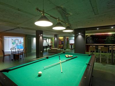 Biljarttafel met keu's in een moderne, gezellige recreatieruimte met bar.