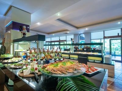 Buffetgebied met diverse gerechten en dranken in een modern restaurant met grote ramen