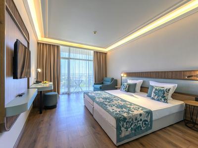 Moderne hotelkamer met tweepersoonsbed, tv en balkon met gordijnen