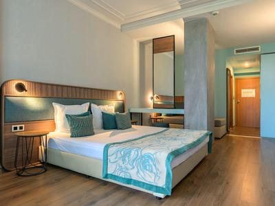 Modern ingericht hotelkamer met tweepersoonsbed en houten vloer