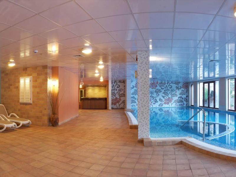 Licht overdekt zwembad met ligstoelen en grote ramen