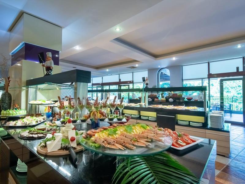 Buffetgebied met diverse gerechten en dranken in een modern restaurant met grote ramen