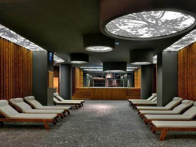 Modern spa relaxation room with loungers and indirect lighting.