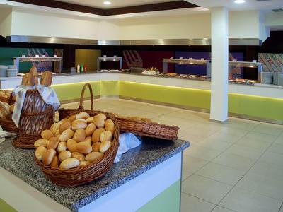 Buffet di panini freschi con cesti su un bancone in una sala colazione luminosa.