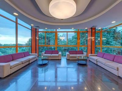 Modern lounge area with large windows and sofas in a hotel with mountain views.