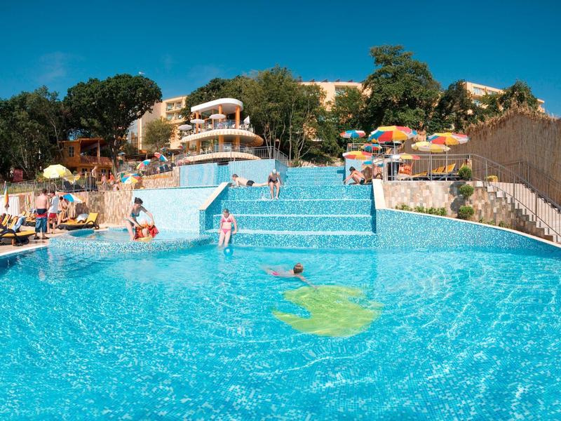 Large swimming pool with sunbeds and people on a sunny day