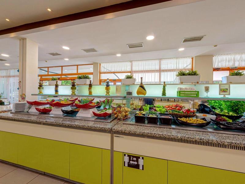 Buffet with various fresh foods in a bright dining area.