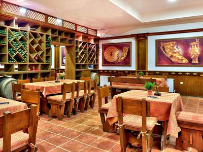 Przytulna jadalnia z drewnianymi meblami i regałami na wino w restauracji lub hotelu.