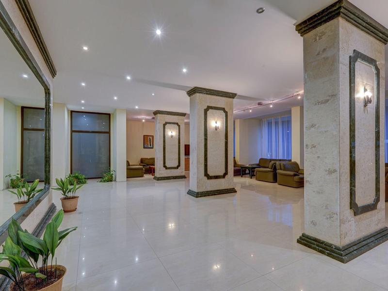 Jasny, nowoczesny hol hotelowy z miejscami do siedzenia i roślinami dekoracyjnymi.