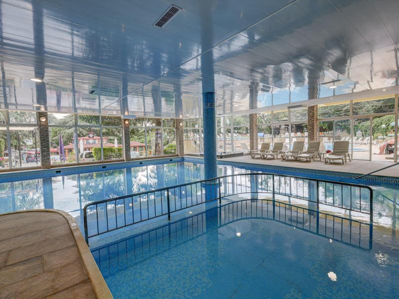 Basen kryty z częścią wodną i panoramicznymi oknami w hotelu.