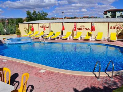 Round outdoor pool with yellow loungers and umbrellas in front of a wall with Sirena branding