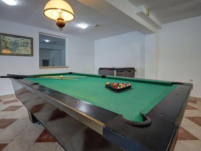 Stół bilardowy z ułożonymi kulami w jasnym pokoju z podłogą z płytek.