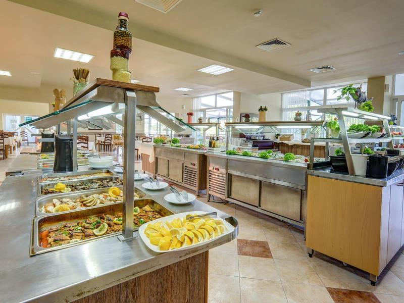 Bufetová oblast s různými teplými jídly a čerstvým ovocem v hotelové restauraci.